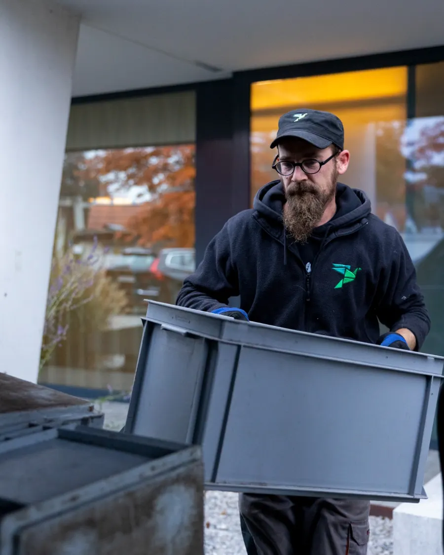 Un chauffeur Oust! transporte une caisse pendant une tournée